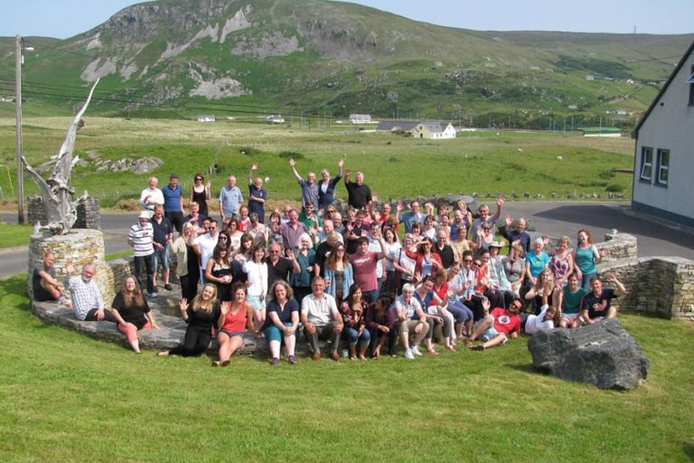 A group of people outside Oideas Gael Language School, enjoying the beautiful view of Donegal
